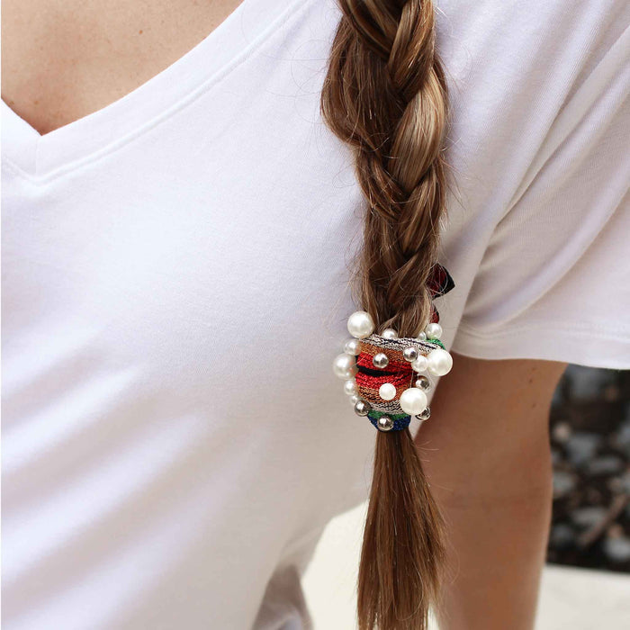 Model wearing Gemelli Jewelry Hair Tie with Vegan Pearl and Silver Ball Studs in Dark Rainbow Print
